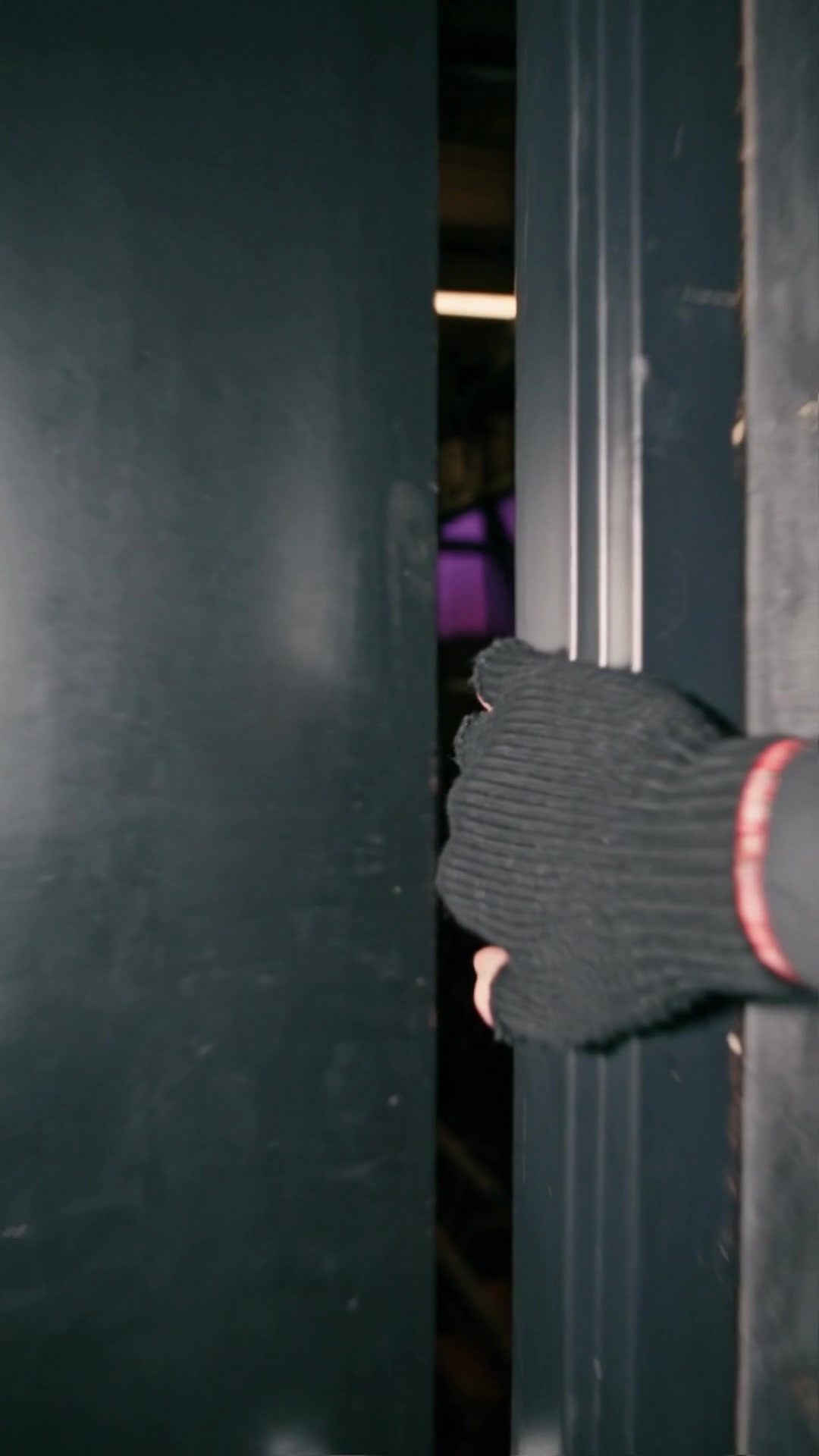 A hand in a black knit glove grabbing the edge of a closing door - Ankin Law dramatization