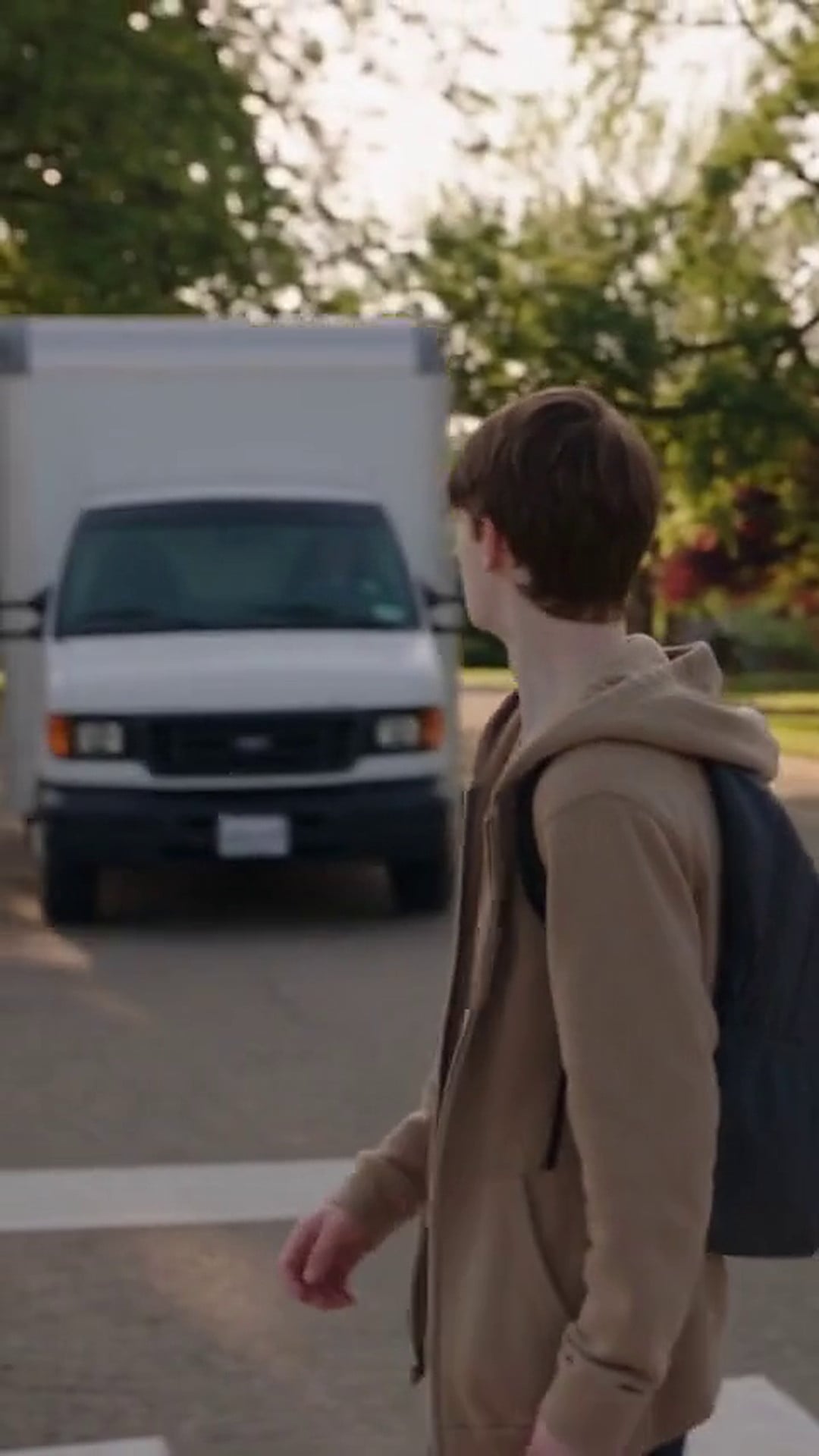 A white box truck coming through a marked crossing towards a pedestrian - Ankin Law dramatization