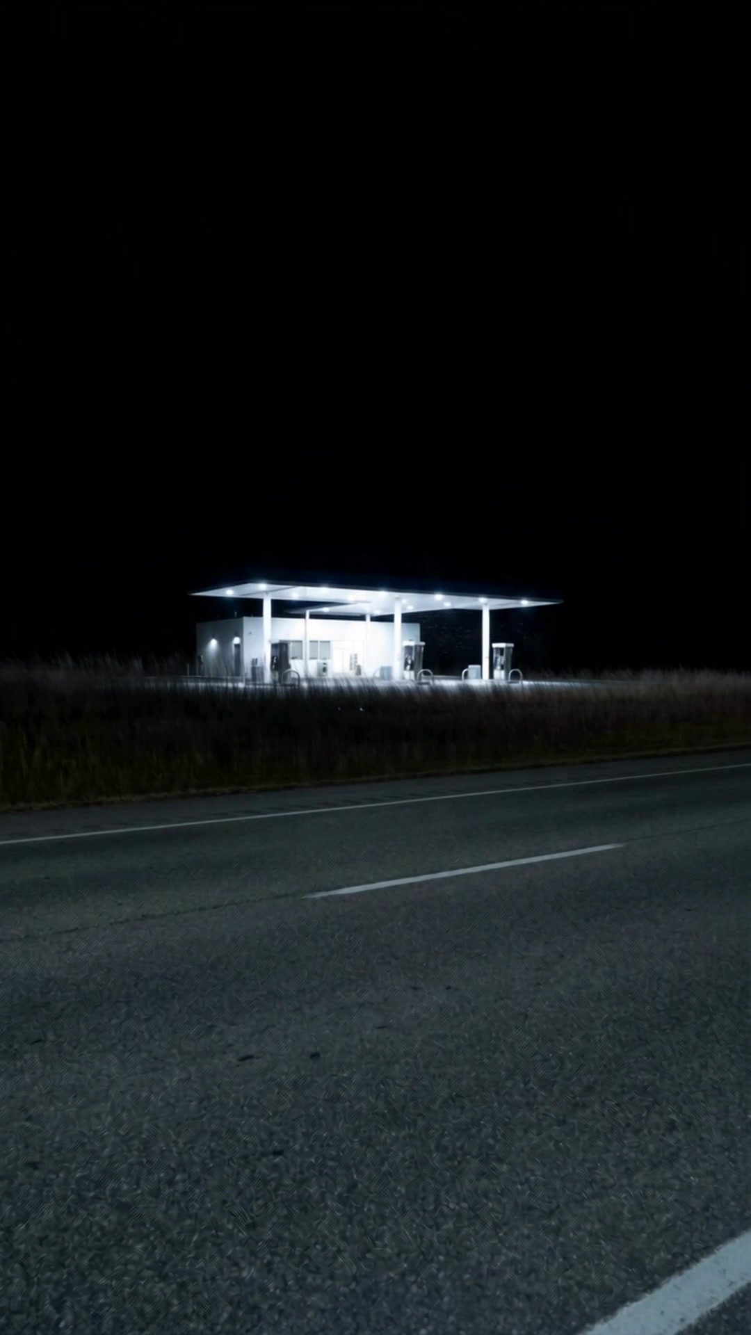 A lone gas station lit up across an empty highway in the middle of the night - Ankin Law dramatization