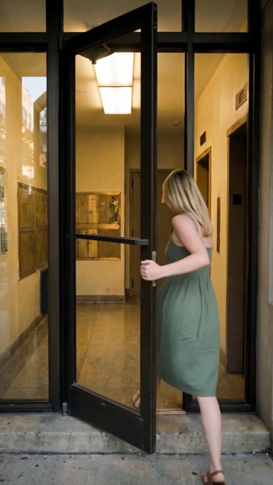A resident stepping through the entrance door of a Chicago apartment building - Ankin Law dramatization