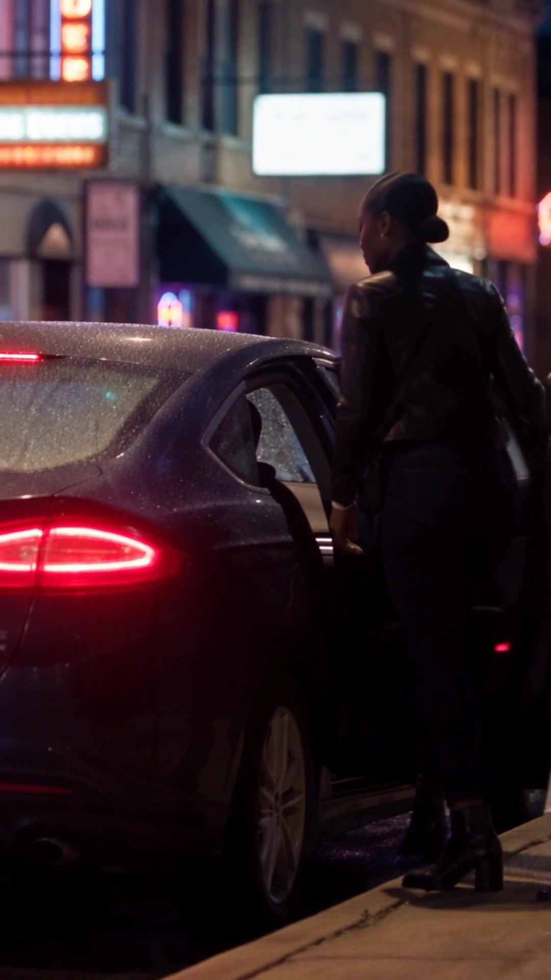 A woman crossing a busy nighttime sidewalk to a car waiting at the curb - Ankin Law dramatization